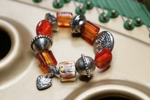 Bali style metal legerings armbnd med orange glasperler og  sdt hjerte vedhng. Str. 18 cm.