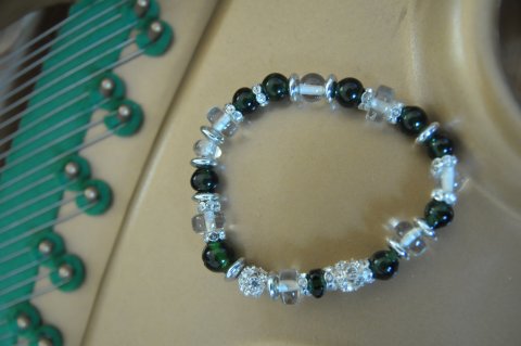 Cool armb�nd holdt i hvide og gr�ntlige nuancer med fors�lvet mellemled. Indeholder bl.a. swarovski mellemled og  fors�lvet kugler .Er lavert med elastik og m�ler ca. 17 cm.