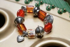 Bali style metal legerings armbnd med orange glasperler og  sdt hjerte vedhng. Str. 18 cm.
