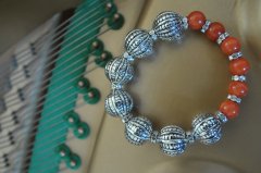 Balystyle armbnd med orange agatperler. Indeholder ogs forslvet swarovski rondeller som mellemled. Lavet med elastik og mler ca .17 cm.