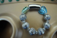 Rostik forslvet armbnd med blstribede hjerte og grntstribede glasperle. Indeholder desuden forslvet baliperler og swarovski mellemled.