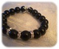 Armbnd med sorte perler med forslvede mellemled.