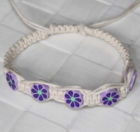 Hvidt knyttet armbnd med lilla fimo perler.