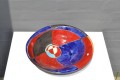 Red and blue dish on small metal feet