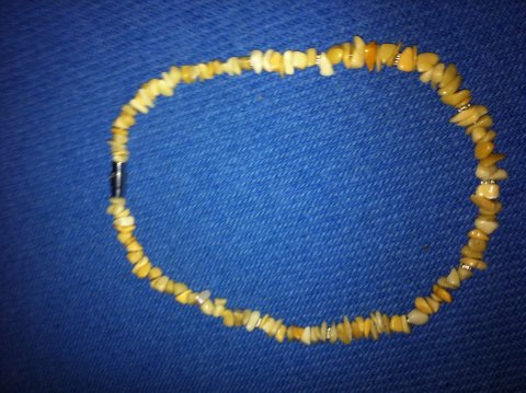 Fin lille kæde med sølvstjerner og tilhørende armbånd på anden side.