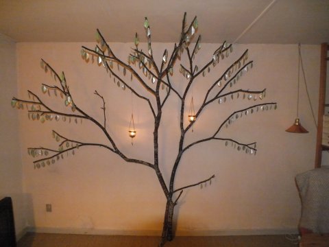 Lotte Rosenkilde Urkraft Kunst. Rumudsmykning i stue. Træ med fyrfadsblade og lyspendler.