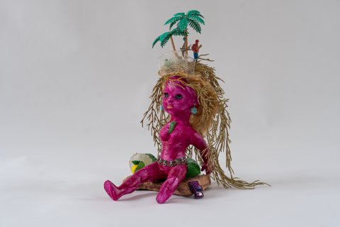 Lotte Rosenkilde. Urkraft Kunst.  Pink, kvindeligt væsen med palmer og guldhår. Dukke og blandede materialer.